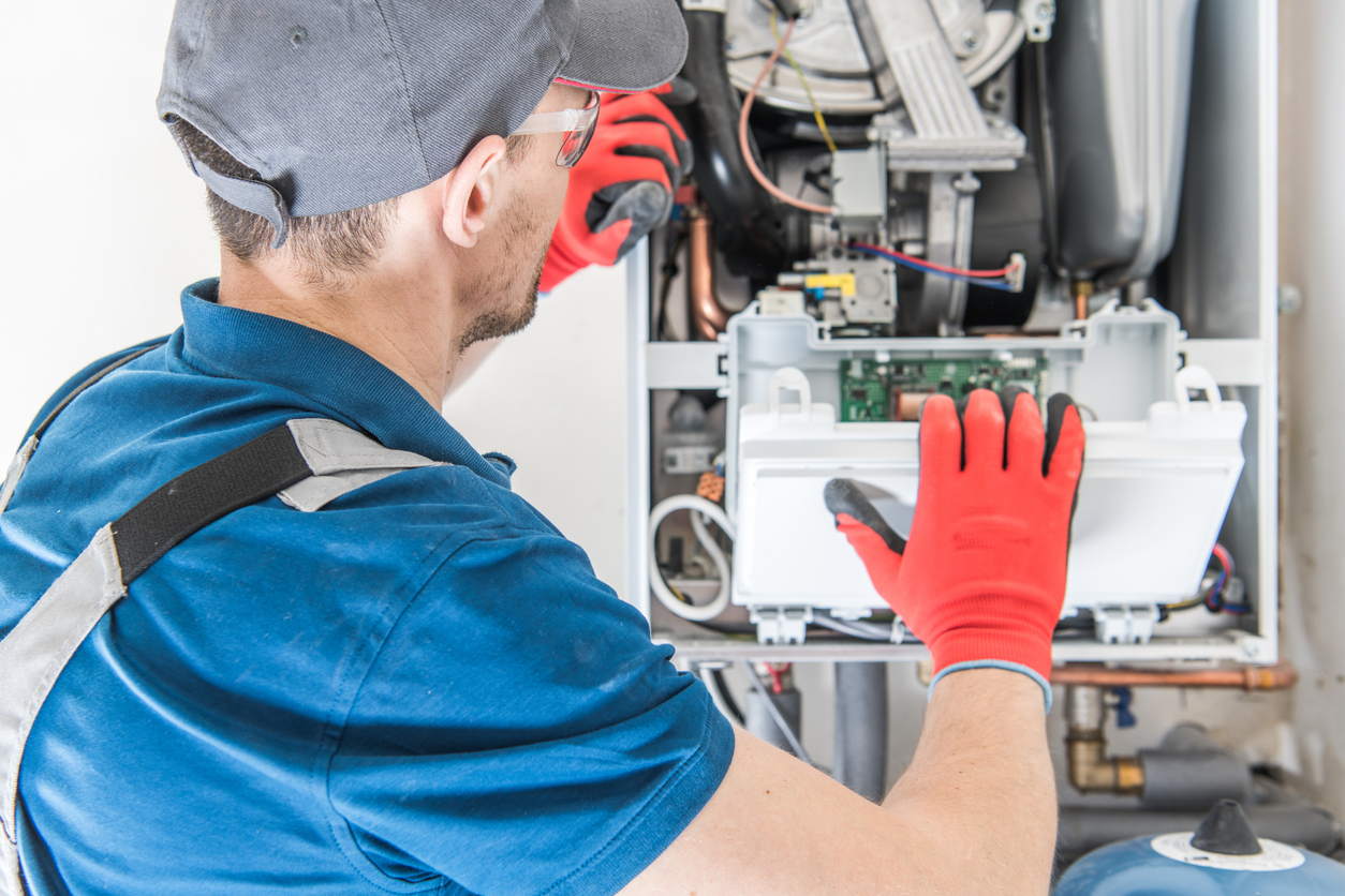 Emergency heating technician repairing a home furnace during an urgent heating service call.